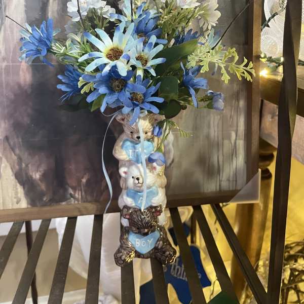 Blue and white flower arrangement in a teddy bear vase with a "boy" accent