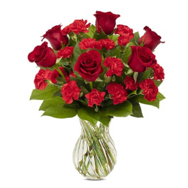 Red roses and carnations in a clear glass vase