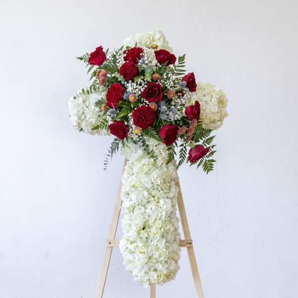 Red roses and white hydrangeas arranged on a standing easel display