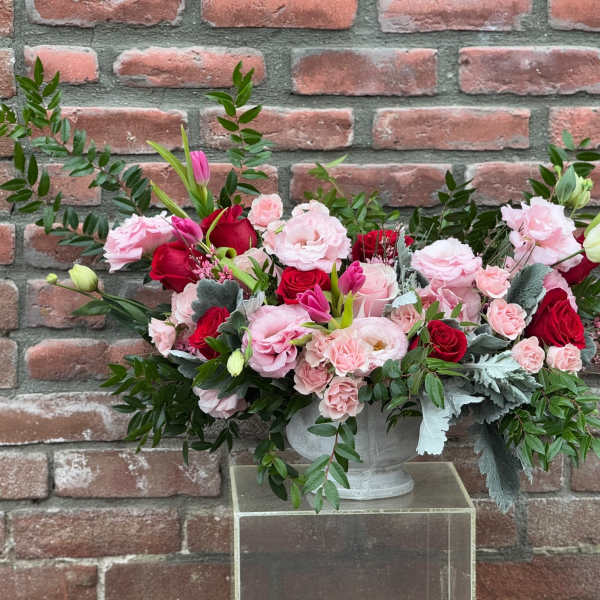 Pink and red floral arrangement in a white vase