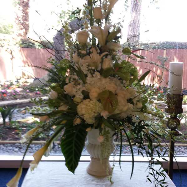 Tall white floral arrangement in a pedestal vase