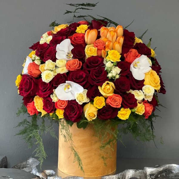 Large bouquet of red, yellow, orange, and white roses in a gold box