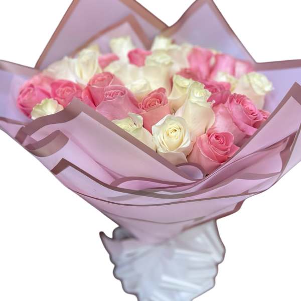 Bouquet of pink and white roses wrapped in lavender paper