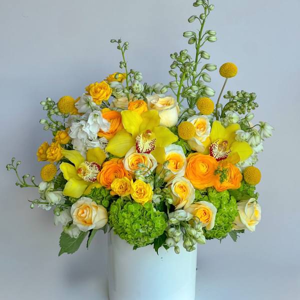 Yellow and white floral arrangement in a white vase