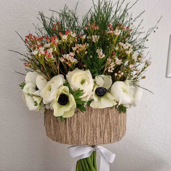 White flower bouquet with a twine-wrapped handle and white ribbon