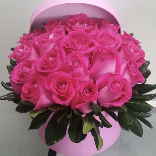 Bouquet of bright pink roses in a round pink box