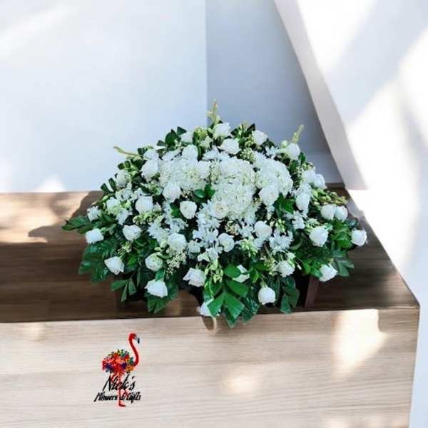 White floral arrangement on a wooden casket