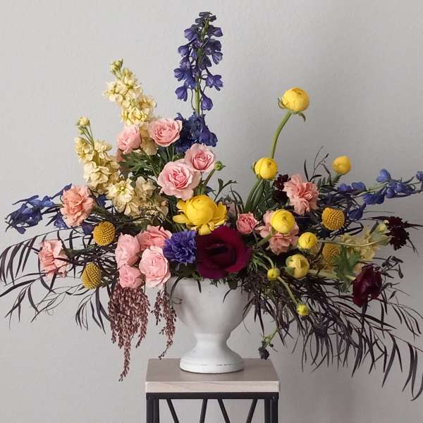 Colorful mixed flower arrangement in a white vase