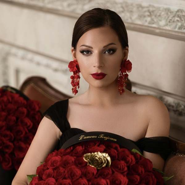 Woman holding a black box filled with red roses