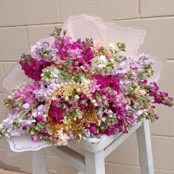 Large bouquet of pink, lavender, and white flowers with a gold handle