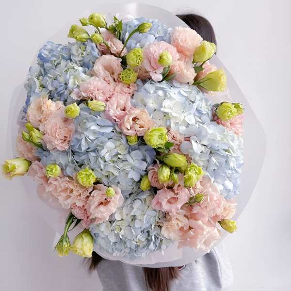 Large pastel bouquet of blue hydrangeas and pink carnations