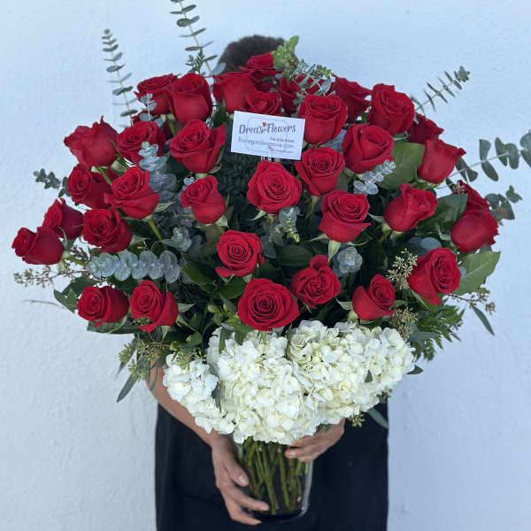 Large bouquet of red roses and white hydrangeas in a glass vase