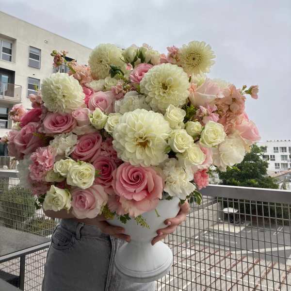 Large pink and white bouquet in a white pedestal vase