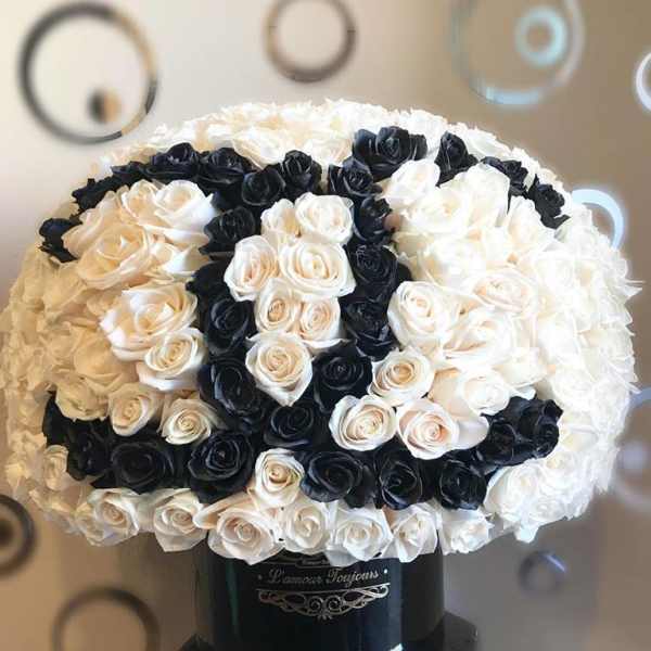 Black and white rose bouquet in a black vase