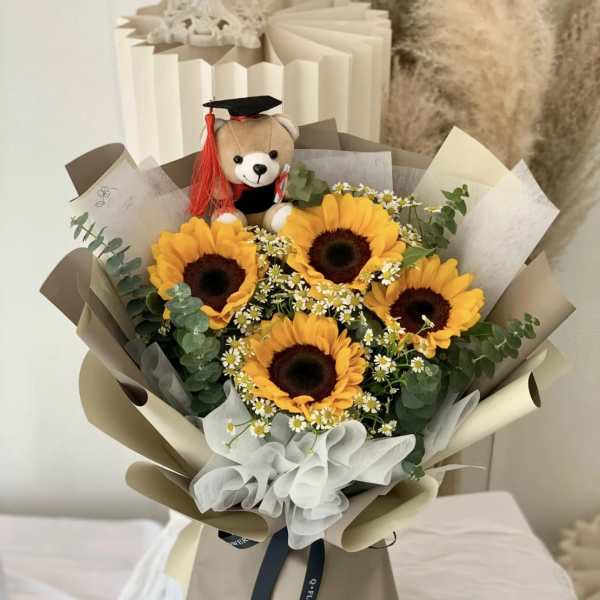 Bouquet of sunflowers with a teddy bear wearing a graduation cap