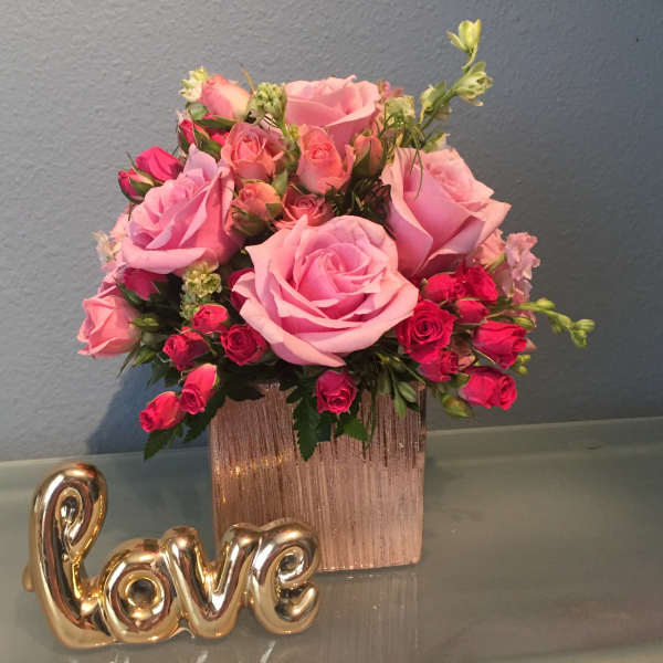 Pink rose bouquet in a rose-gold vase with a gold "love" decoration