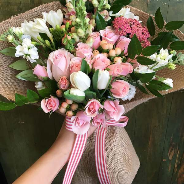 Pink rose bouquet with white tulips and a striped ribbon