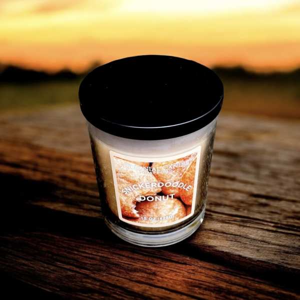 A scented candle in a glass jar with a black lid