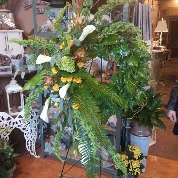 Large standing floral spray with white calla lilies and yellow roses