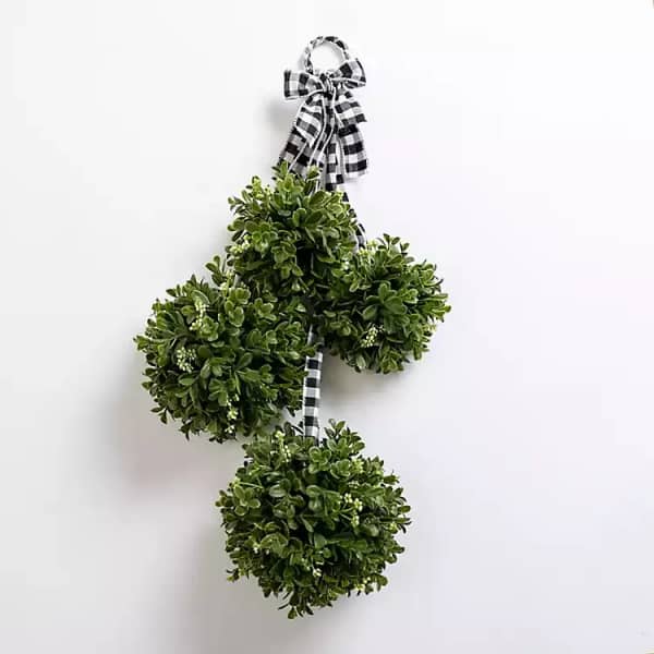 Three green topiary balls tied with a black-and-white check ribbon