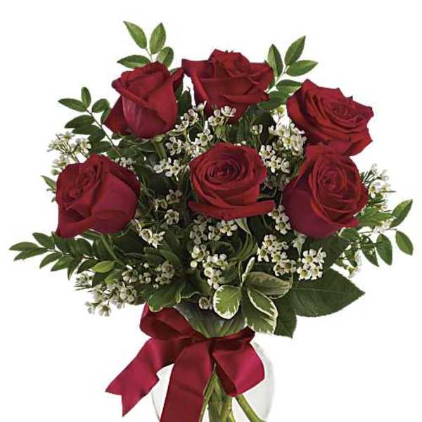 Bouquet of red roses with baby's breath in a glass vase tied with a red ribbon