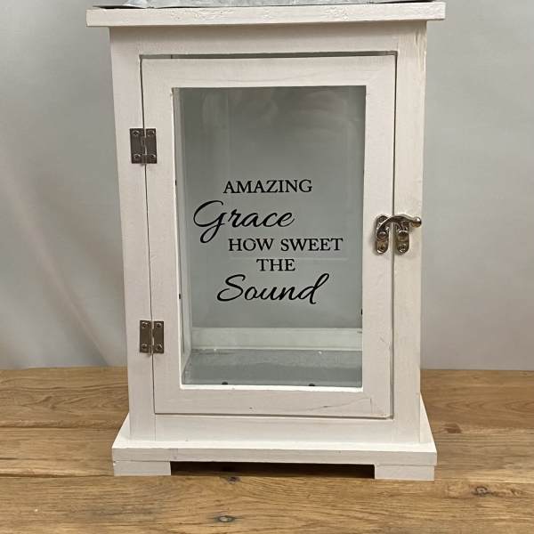White lantern with glass door and "Amazing Grace" text
