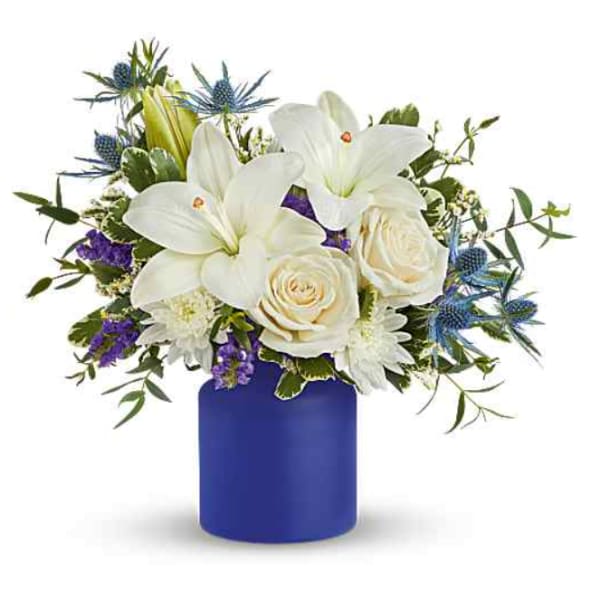 White lilies and roses in a blue vase with purple accents