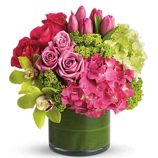 Pink roses and tulips with hydrangea in a green glass vase