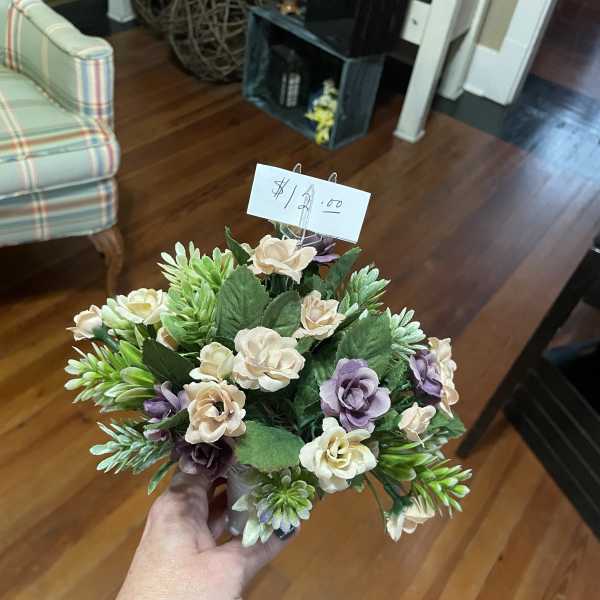 Small bouquet of cream and lavender flowers in a hand