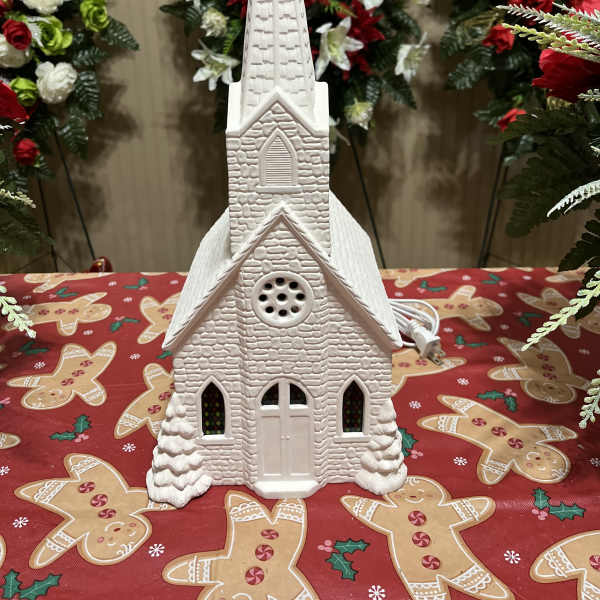 White church-shaped holiday decoration on a gingerbread tablecloth