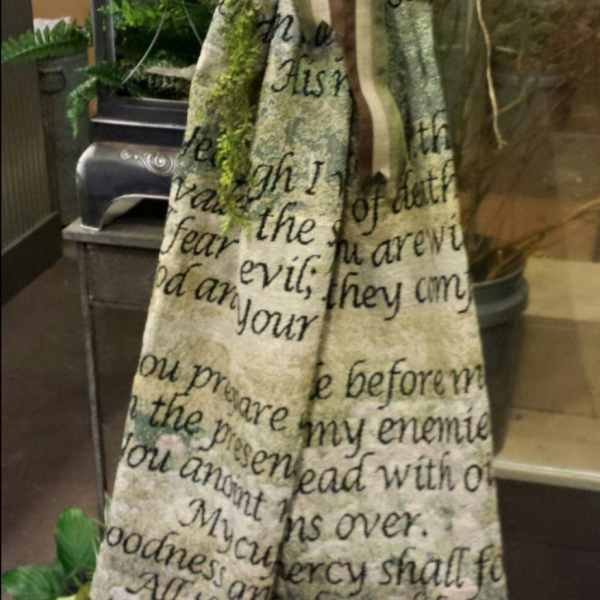 Tall decorative fabric banner with a large striped bow and greenery