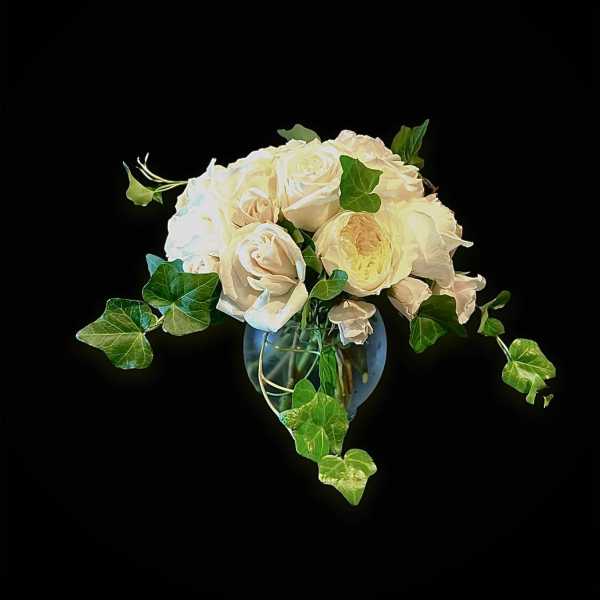 White rose bouquet in a glass vase with trailing ivy