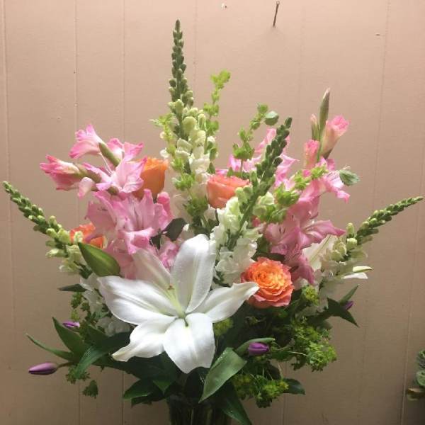 Tall bouquet of pink and white flowers in a clear glass vase
