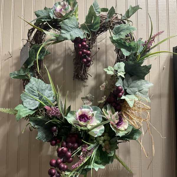 Decorative grapevine wreath with faux cabbage roses and purple grapes