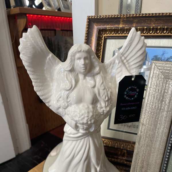 White angel figurine with outstretched wings on a table
