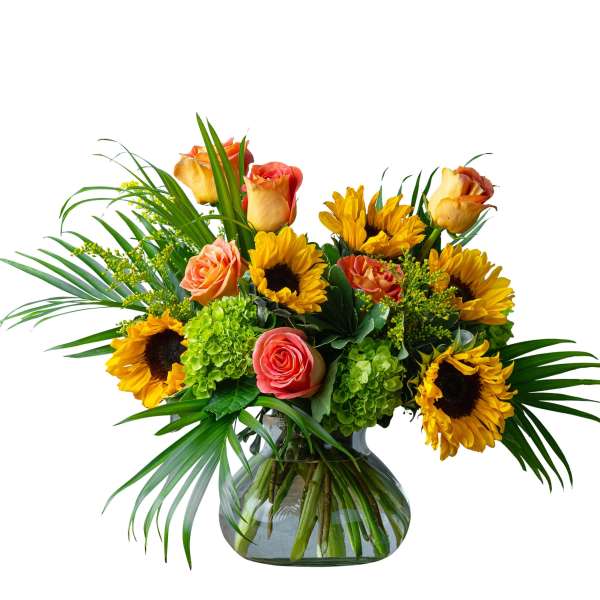 Bouquet of sunflowers and peach roses in a glass vase