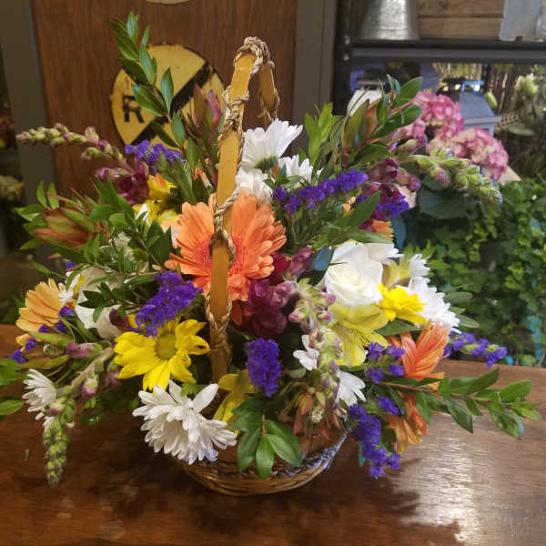 Mixed flower basket with daisies, gerbera daisies, and roses