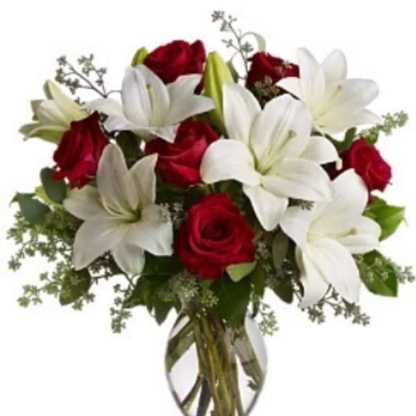 Red roses and white lilies in a clear glass vase