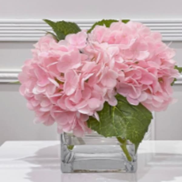 Pink hydrangea bouquet in a clear square vase
