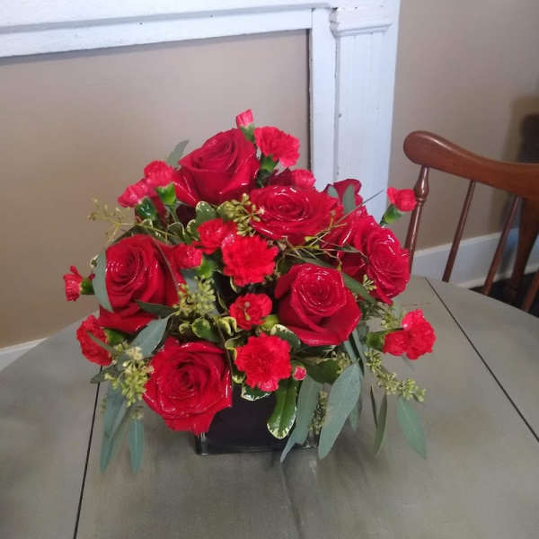 Red roses and carnations arranged in a black vase