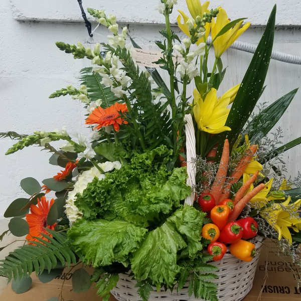 Basket arrangement with yellow lilies, orange gerberas, and vegetables