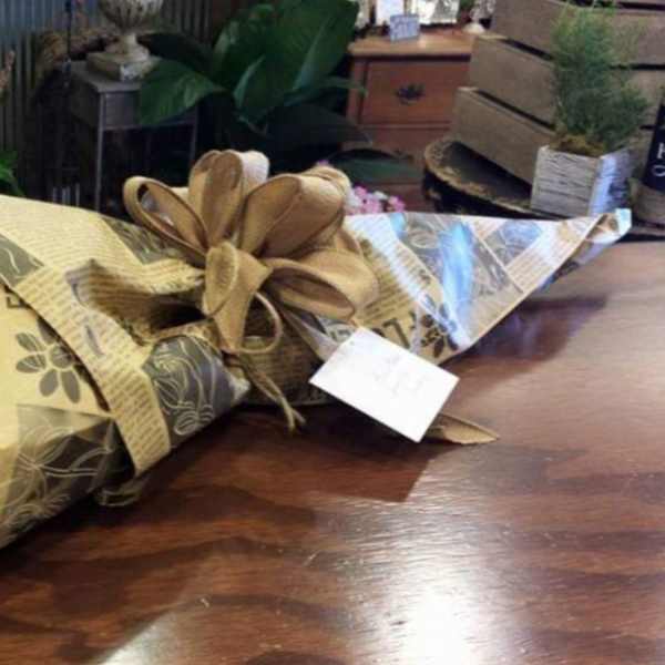 Bouquet of red roses and baby's breath wrapped in brown paper with a ribbon