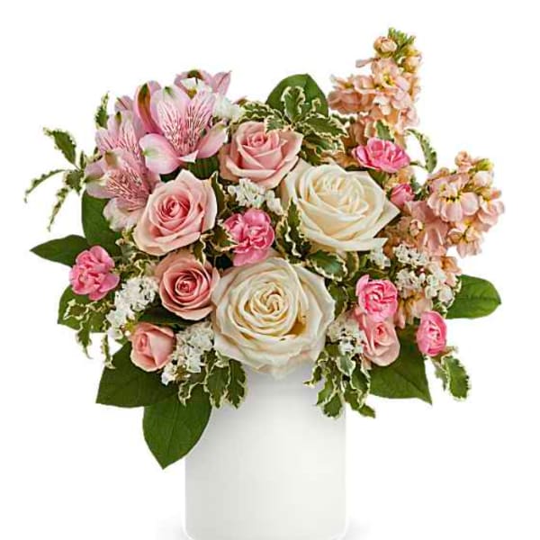 Pink and white roses in a white vase with mixed blooms