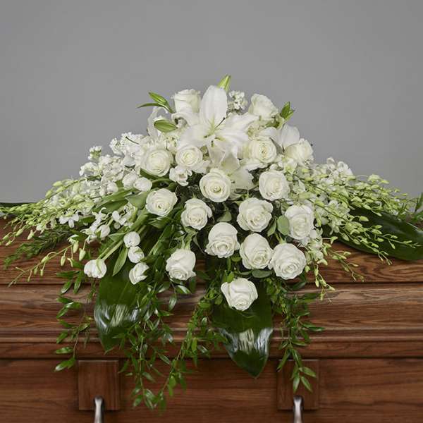 White floral casket spray with roses and lilies