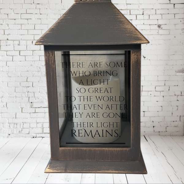 Wooden lantern with a memorial quote on the glass front