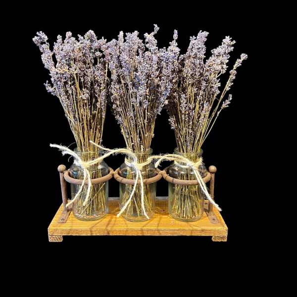 Three jars of dried lavender tied with twine on a wooden tray