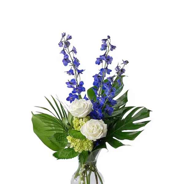 White roses and blue flowers in a glass vase