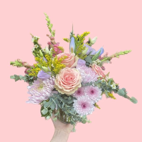 Handheld bouquet of pastel roses, chrysanthemums, and mixed blooms