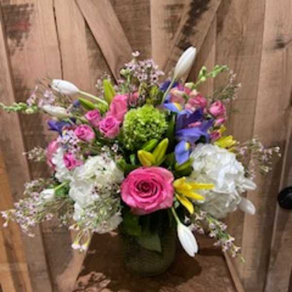 Colorful mixed bouquet in a vase with pink roses and white lilies
