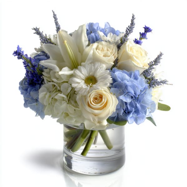 Blue and white bouquet with roses, hydrangeas, and lilies in a glass vase